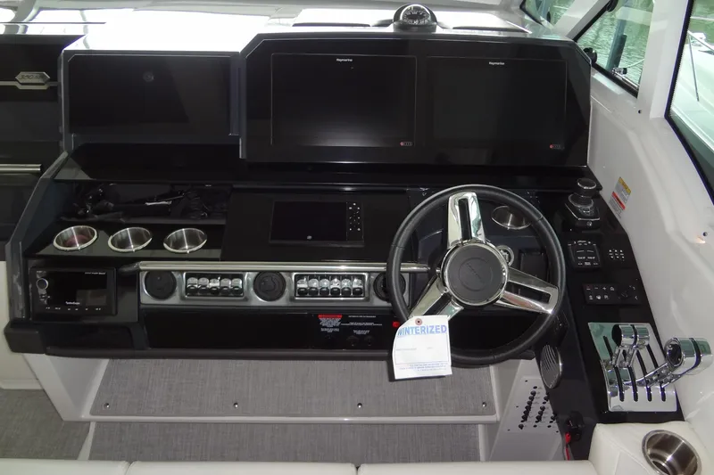 Slide: The Image of 2023 Formula 380 Super Sport Crossover I/O dashboard with modern controls and cup holders. - 35