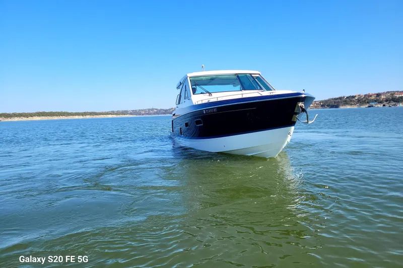 Slide: The Image of 2023 Formula 380 Super Sport Crossover I/O boat cruising on a sunny lake. - 6