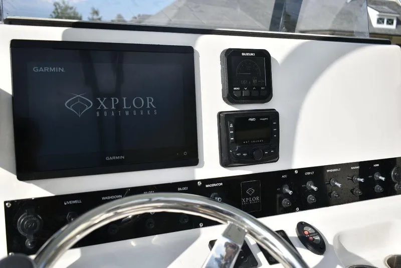 Slide: The Image of Dashboard of 2023 Xplor X24 boat featuring Garmin and Suzuki displays. - 13