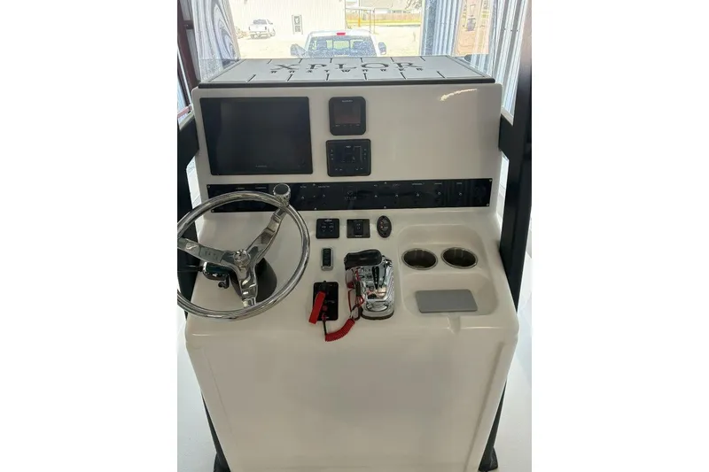 Slide: The Image of 2023 Xplor X24 boat console with steering wheel, controls, and display panel. - 19