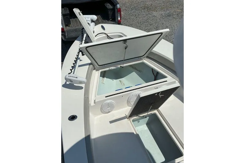 Slide: The Image of 2023 Xplor X24 boat with open storage compartments and trolling motor. - 22