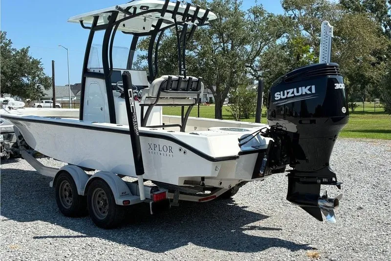 Slide: The Image of 2023 Xplor X24 boat with Suzuki 300 engine on a trailer, parked outdoors. - 3