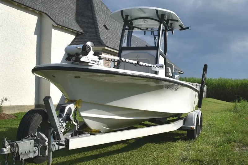 Slide: The Image of 2023 Xplor X24 boat on trailer, parked on grass near a house. - 6