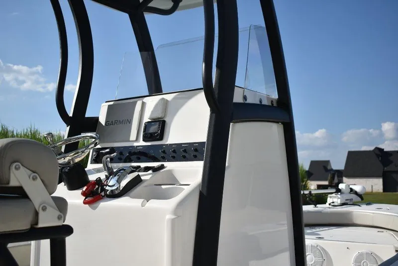 Slide: The Image of 2023 Xplor X24 boat console with Garmin navigation, steering wheel, and controls under clear blue sky. - 9