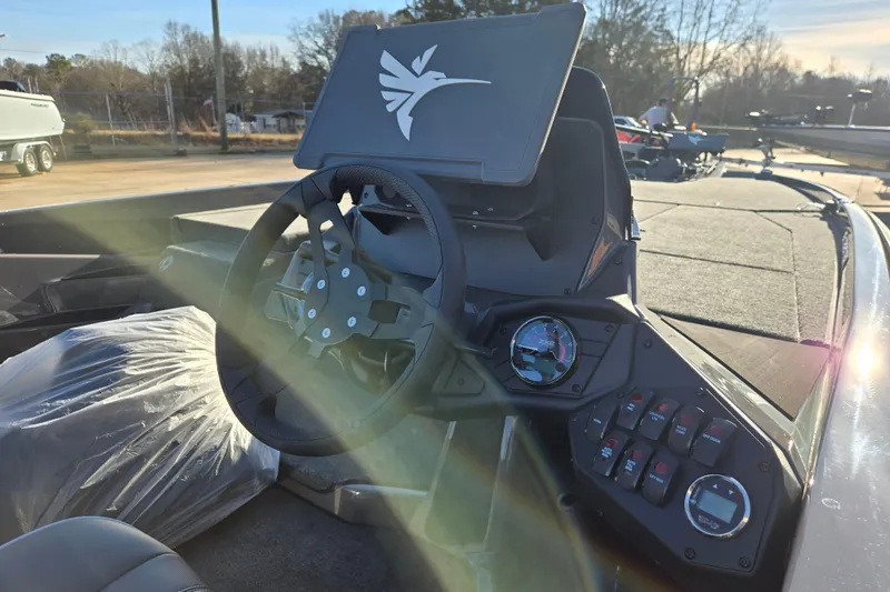 Slide: The Image of 2026 Skeeter ZXE21 boat dashboard with steering wheel and control panel in sunlight. - 13