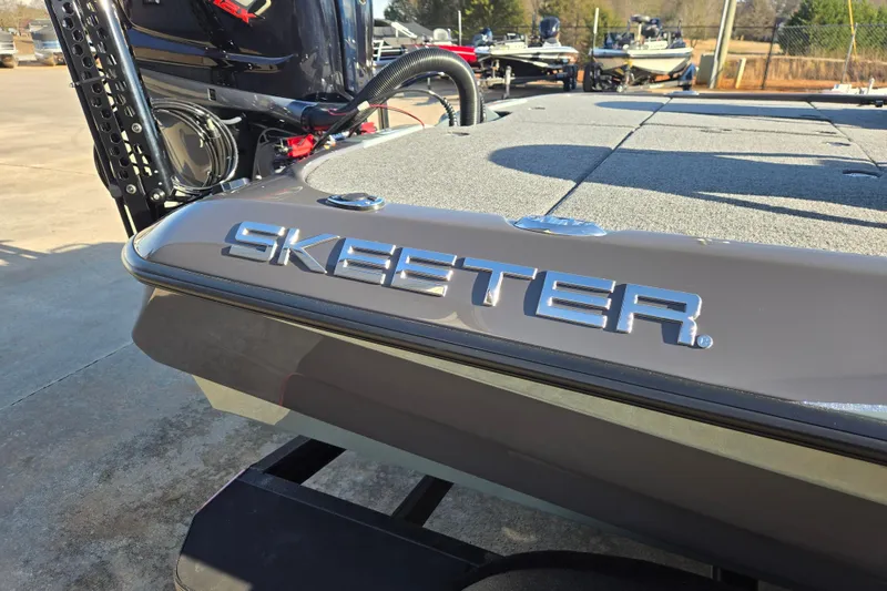 Slide: The Image of 2026 Skeeter ZXE21 boat with sleek design and logo, parked outdoors. - 27