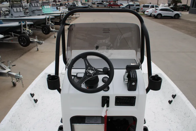 Slide: The Image of 2026 Freedom Boats 16' Eagle console with steering wheel and controls, parked in a marina. - 7