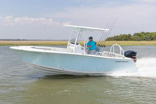 Slide: The Image of 2020 Sportsman Heritage 231 Center Console boat with rod holders and speakers under blue sky. - 12
