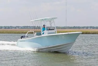 Slide: The Image of 2020 Sportsman Heritage 231 Center Console boat with tan seating, parked near covered boats. - 9