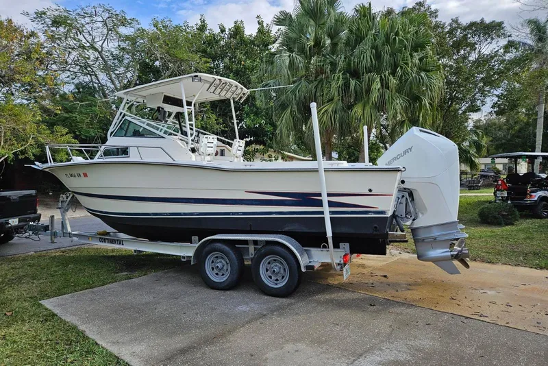 Slide: The Image of 1990 Hydra-Sports Vector 2500 CC boat on trailer, parked outdoors with trees in background. - 3