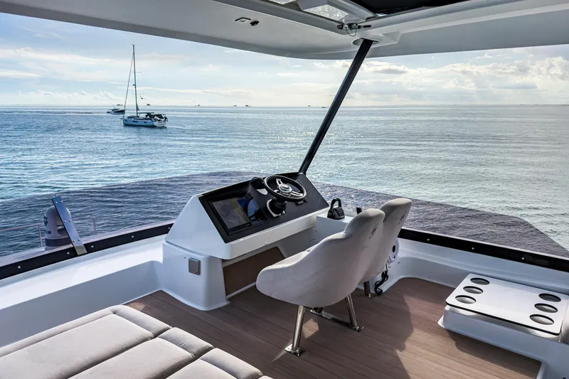 Slide: The Image of 2022 Fountaine Pajot MY6 yacht helm with ocean view and distant sailboats. - 10