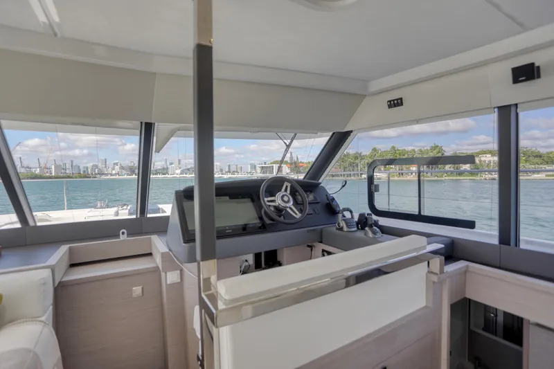 Slide: The Image of 2022 Fountaine Pajot MY6 yacht interior with helm, overlooking scenic waterfront. - 30
