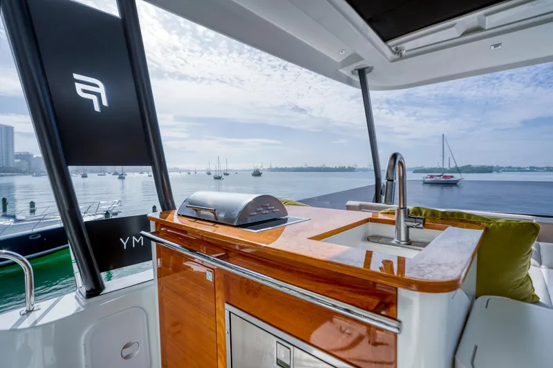 Slide: The Image of Luxury Fountaine Pajot MY6 yacht with sleek outdoor kitchen, overlooking serene marina. - 9