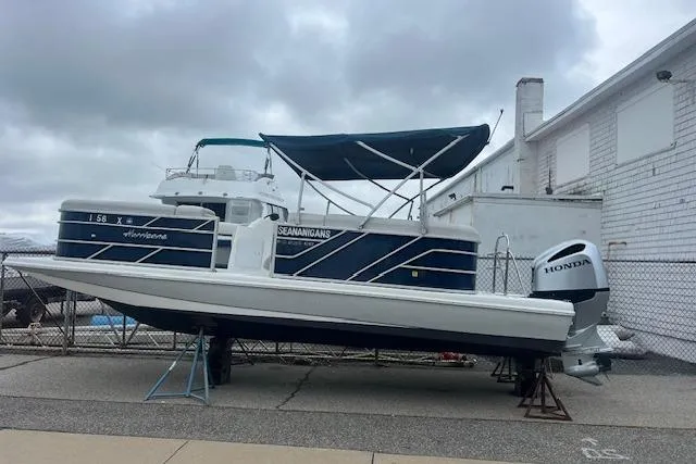 Slide: The Image of 2020 Hurricane FunDeck 236SB OB boat with Honda outboard motor, docked outdoors. - 2