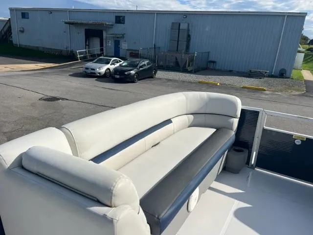 Slide: The Image of 2020 Hurricane FunDeck 236SB OB boat with spacious seating, parked near industrial buildings. - 14