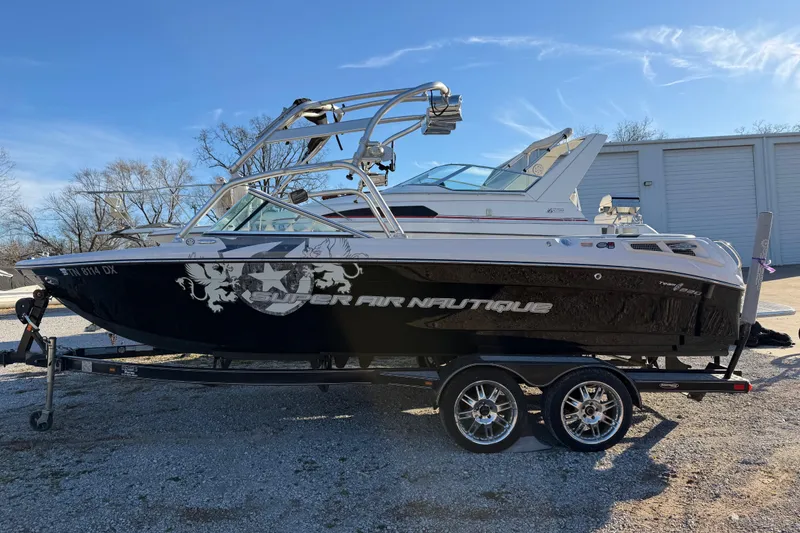 The Image of 2008 Nautique Super Air Nautique 220 boat on trailer, parked outdoors. - 0