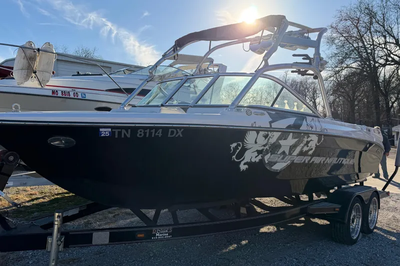 Slide: The Image of 2008 Nautique Super Air Nautique 220 boat on trailer, sunlit background. - 2