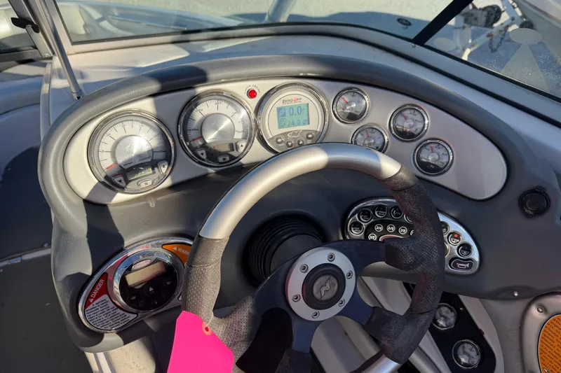 Slide: The Image of Dashboard of a 2008 Nautique Super Air Nautique 220 boat with gauges and steering wheel. - 7