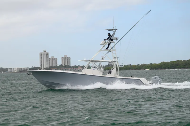 The Image of 2023 SeaVee 420Z boat cruising on open water near city skyline. - 1