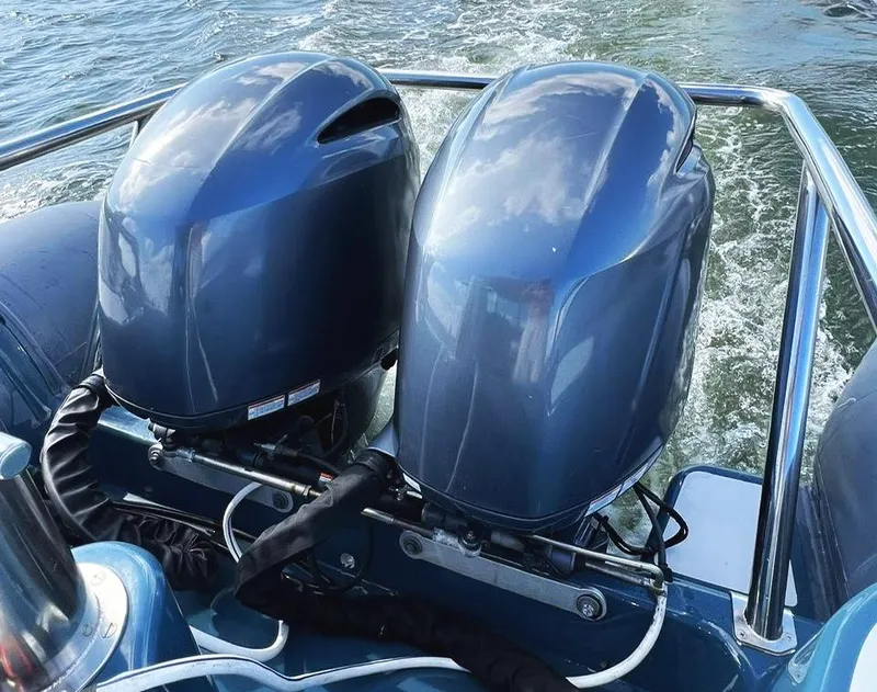Slide: The Image of Twin outboard motors on a 2000 Protector Targa 28 boat, cruising on water. - 10