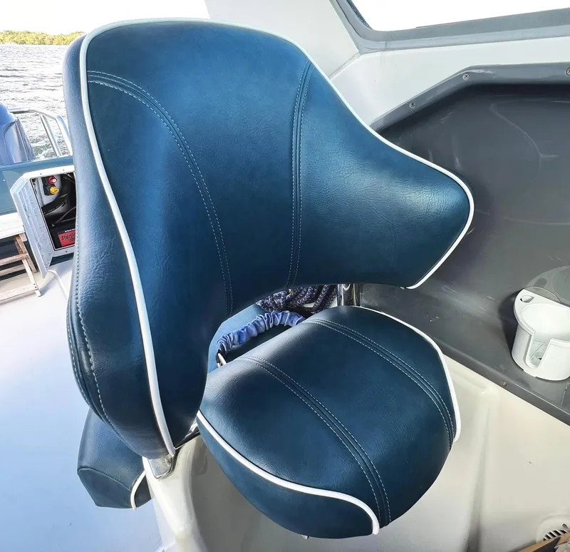 Slide: The Image of Blue captain's chair on a 2000 Protector Targa 28 boat, featuring white trim. - 13