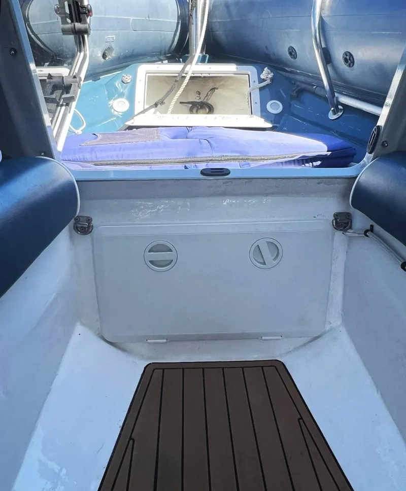 Slide: The Image of Interior view of a 2000 Protector Targa 28 boat, featuring blue and white seating. - 27