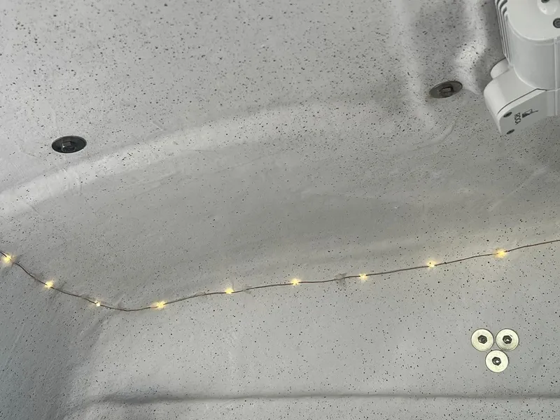 Slide: The Image of Interior of 2000 Protector Targa 28 boat with string lights and fixtures. - 30