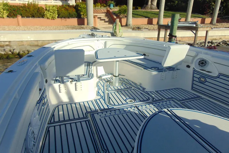 Slide: The Image of 2019 Stamas 390 Tarpon boat interior with seating and table, docked by a waterfront. - 7