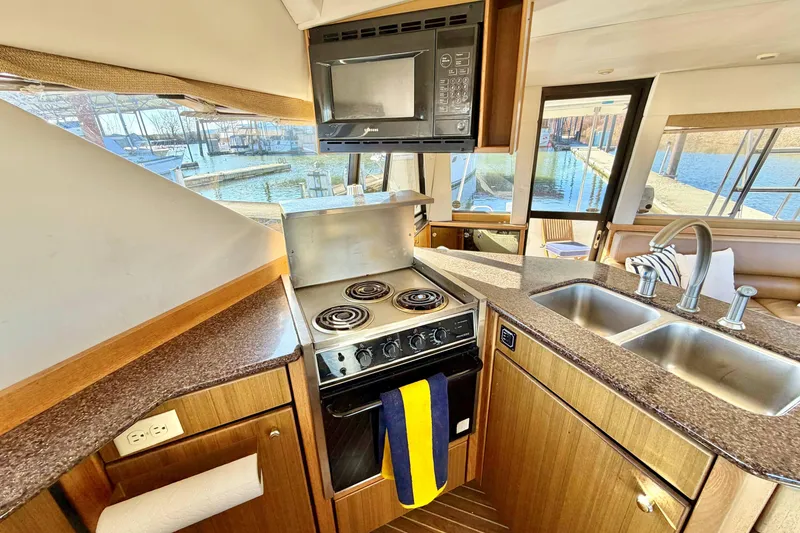 Slide: The Image of 2002 Bayliner 3988 Command Bridge Motoryacht kitchen with stove, microwave, and dual sink. - 10