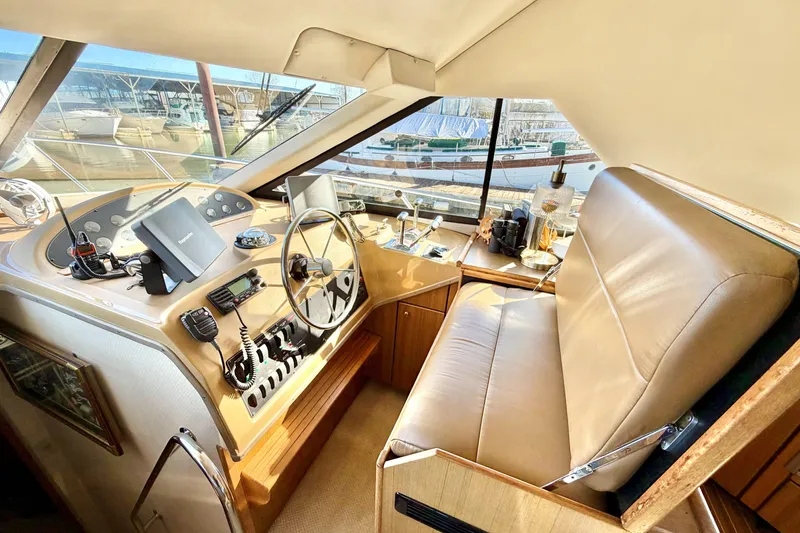Slide: The Image of 2002 Bayliner 3988 Command Bridge Motoryacht helm with steering wheel and navigation equipment. - 12