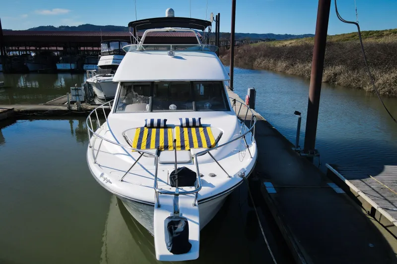 Slide: The Image of 2002 Bayliner 3988 Command Bridge Motoryacht docked in a serene marina setting. - 4