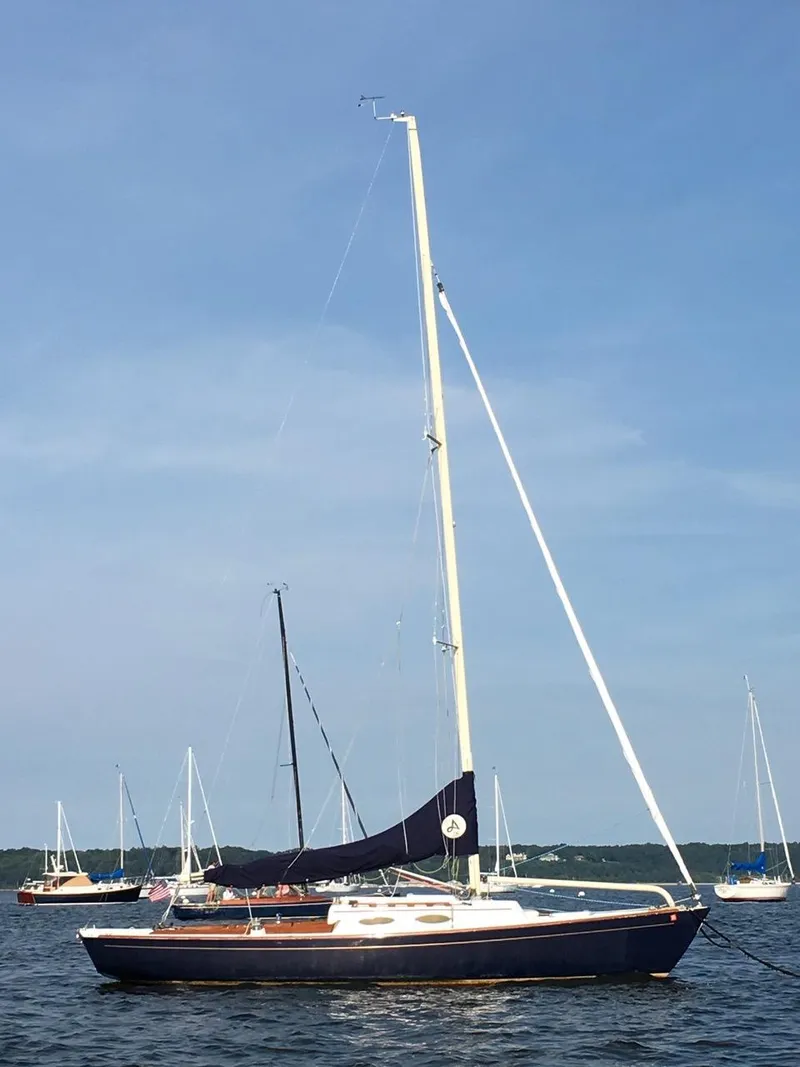 The Image of 2004 Alerion Express 28 sailboat on calm water, clear sky background. - 0