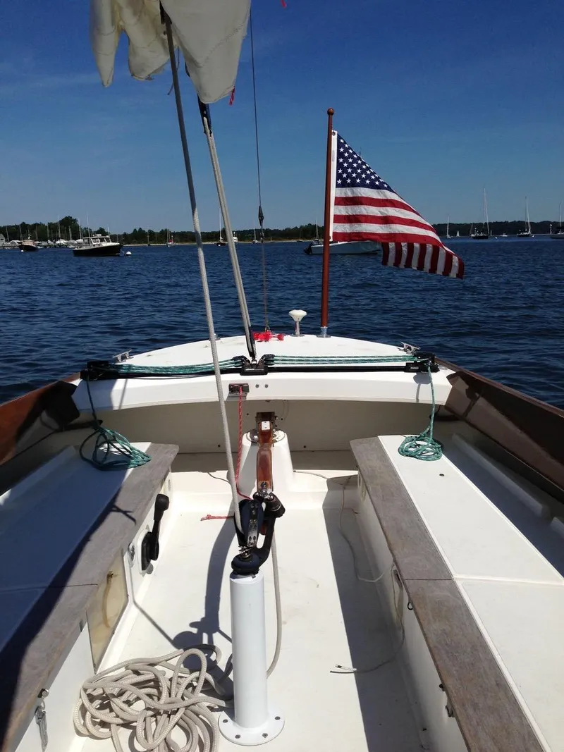 Slide: The Image of 2004 Alerion Express 28 sailboat with American flag on calm water. - 3