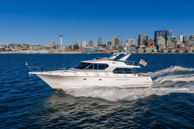 Slide: The Image of 1998 West Bay 58 Pilothouse Motor Yacht cruising near city skyline. - 0