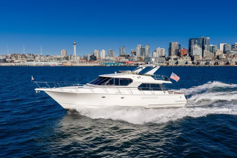 Slide: The Image of 1998 West Bay 58 Sonship Pilothouse MY cruising near city skyline on sunny day. - 12