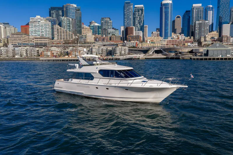 Slide: The Image of 1998 West Bay 58 Pilothouse Motor Yacht cruising near city skyline. - 2