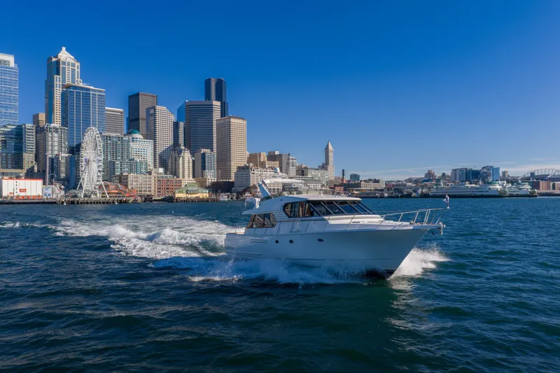 Slide: The Image of 1998 West Bay 58 Pilothouse Motor Yacht cruising near city skyline and Ferris wheel. - 3