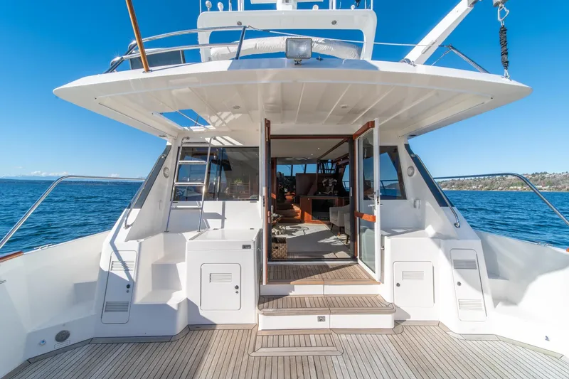 Slide: The Image of 1998 West Bay 58 Sonship Pilothouse MY yacht, open deck view, sunny day, ocean backdrop. - 57