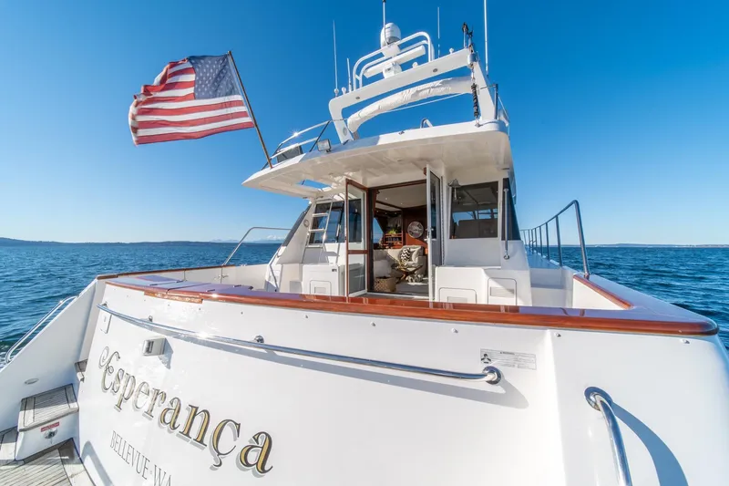 Slide: The Image of 1998 West Bay 58 Sonship Pilothouse MY yacht with American flag on open water. - 58