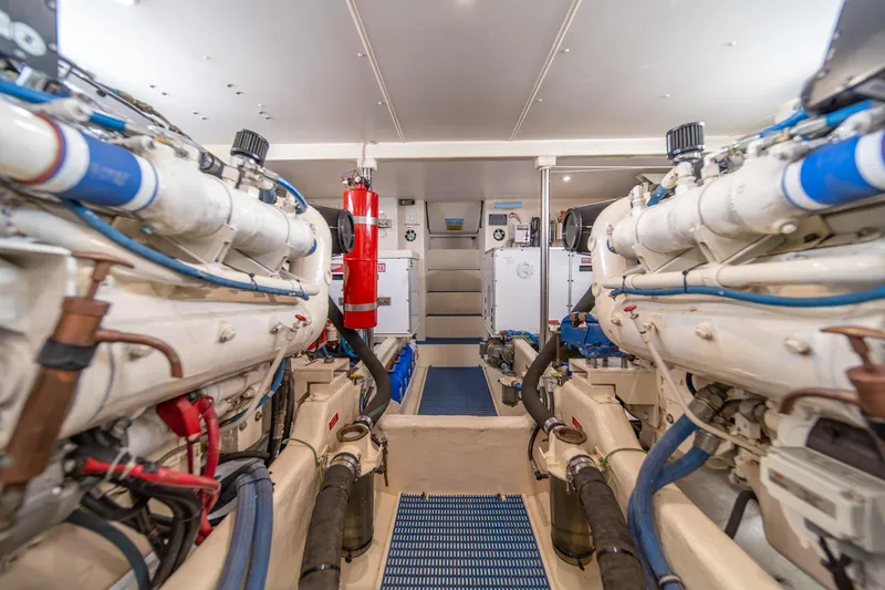 Slide: The Image of Engine room of 1998 West Bay 58 Sonship Pilothouse MY, featuring dual engines and fire extinguisher. - 64