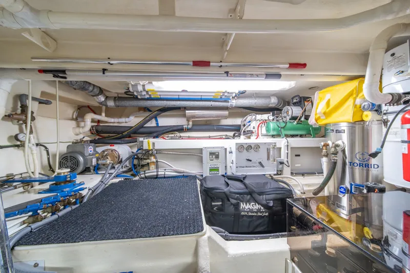 Slide: The Image of Engine room of 1998 West Bay 58 Sonship Pilothouse MY, featuring equipment and storage. - 72