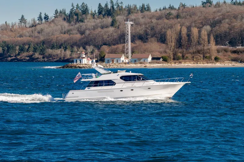 Slide: The Image of 1998 West Bay 58 Sonship Pilothouse MY cruising on blue waters near a scenic shoreline. - 76