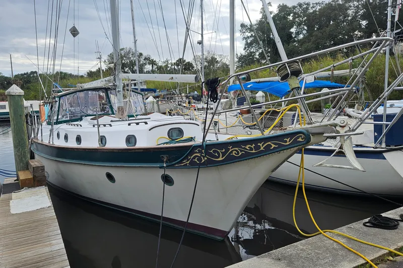 Slide: The Image of 1979 CSY 44 CC sailboat docked at marina, featuring classic design and decorative trim. - 2