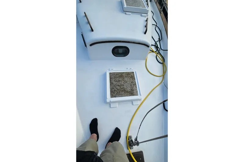 Slide: The Image of 1979 CSY 44 CC sailboat deck with hatches and coiled yellow hose. - 3