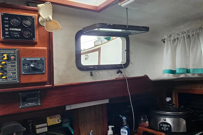 Slide: The Image of Interior of a 1979 CSY 44 CC sailboat with control panels and a small window. - 34