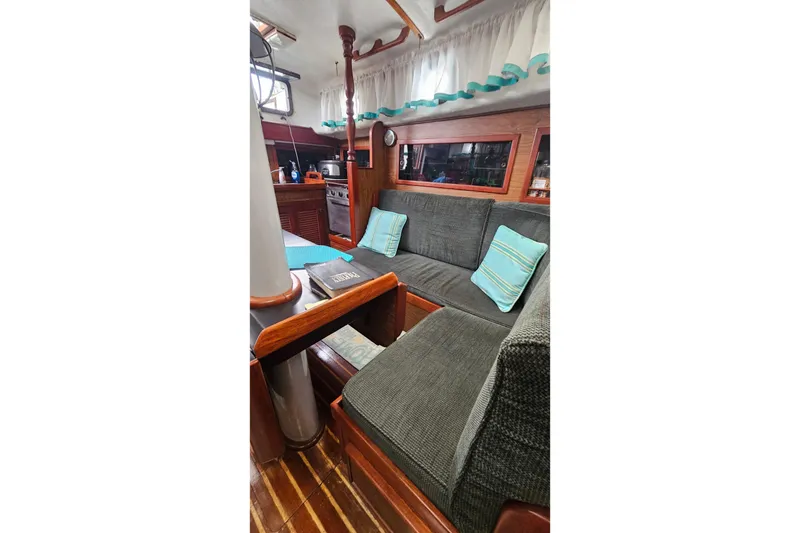 Slide: The Image of Cozy interior of 1979 CSY 44 CC sailboat with cushioned seating and wooden accents. - 36