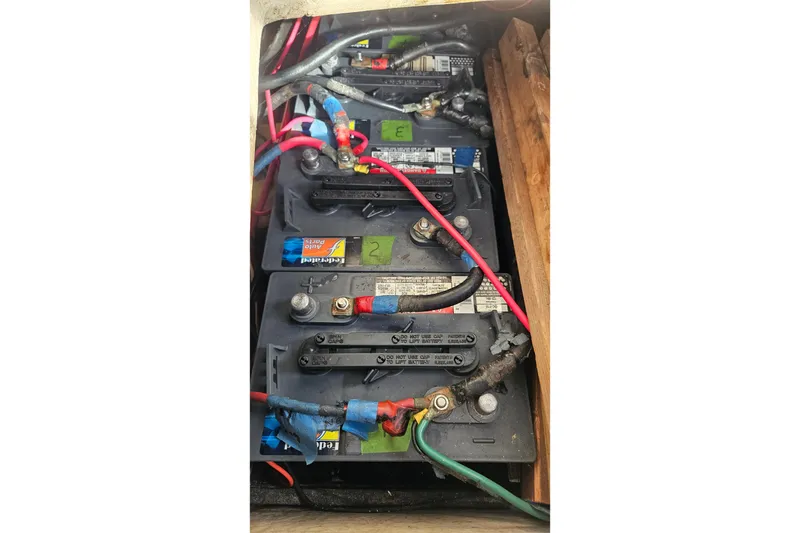 Slide: The Image of Battery compartment of a 1979 CSY 44 CC sailboat with multiple connected batteries. - 46
