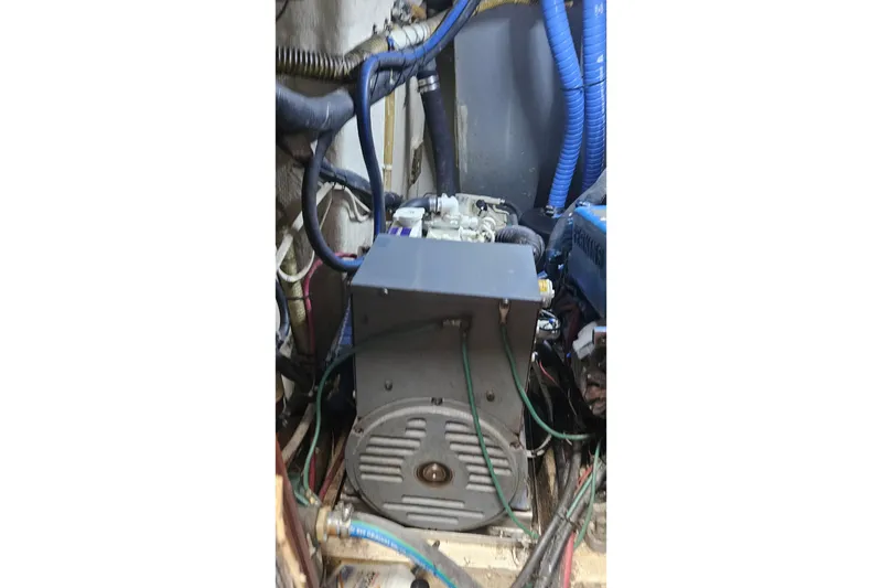 Slide: The Image of Engine compartment of a 1979 CSY 44 CC sailboat with visible wiring and hoses. - 49