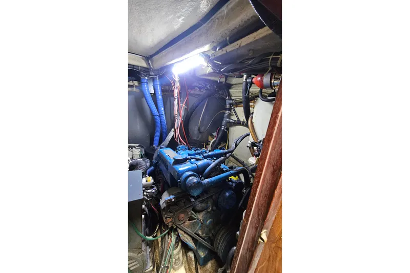 Slide: The Image of Engine room of a 1979 CSY 44 CC sailboat, featuring blue engine components. - 52