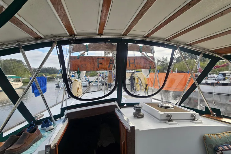 Slide: The Image of Interior view of a 1979 CSY 44 CC sailboat cockpit with marina background. - 7
